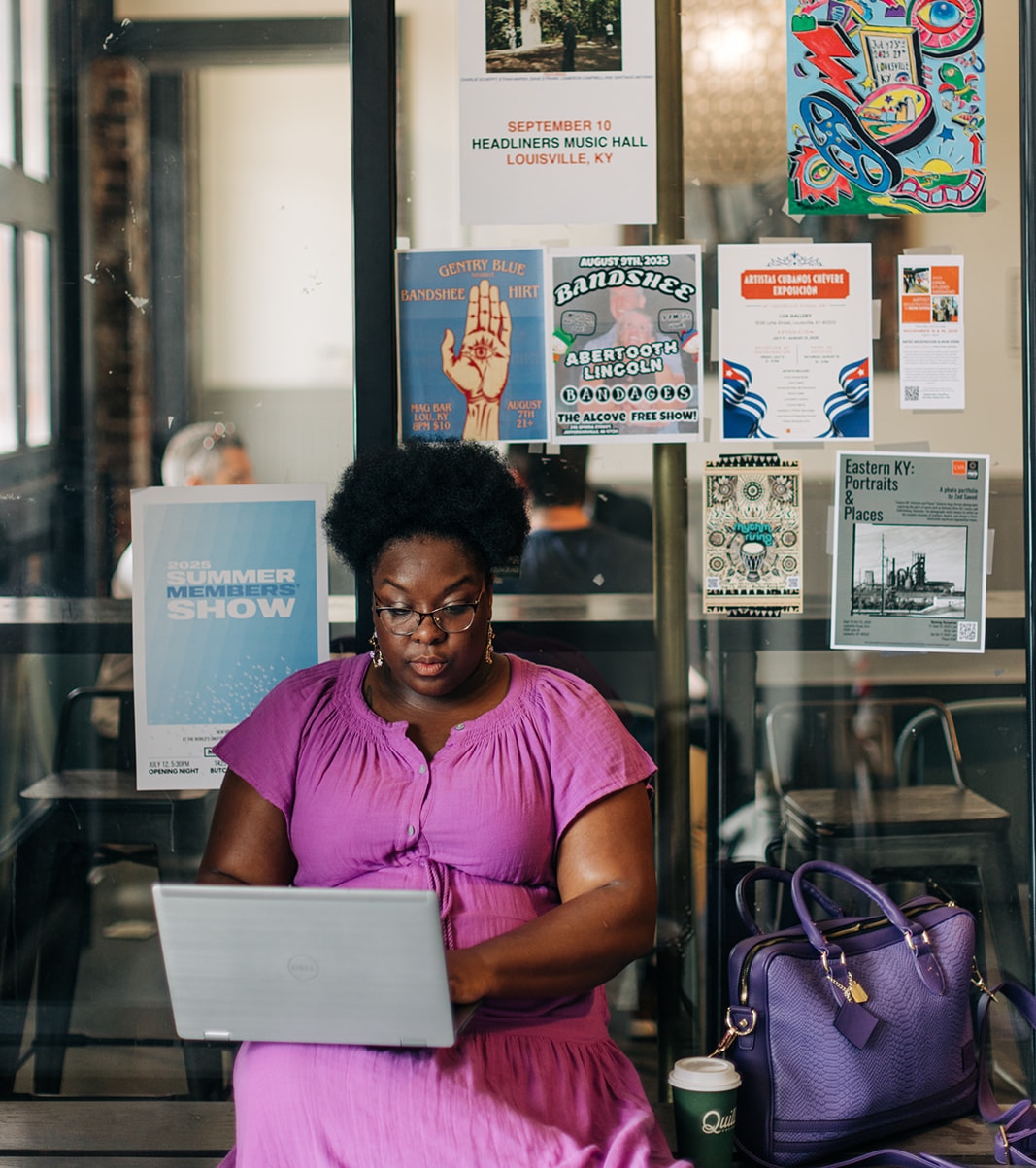 Woman working on laptop in café.